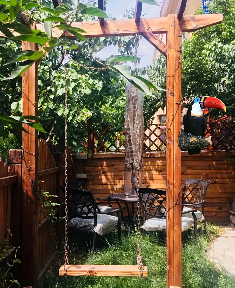 Wooden swing in a garden setting with a wooden pergola and outdoor furniture.