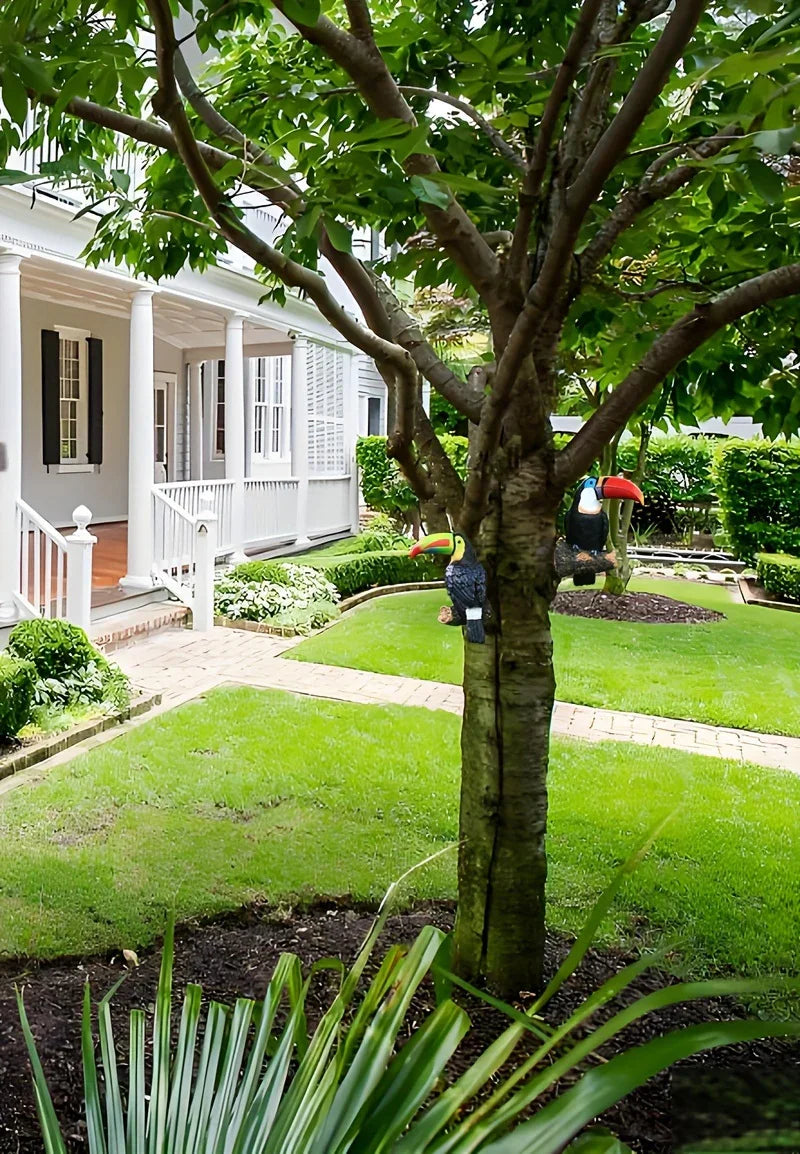 Lush garden with a tree in front of a white house