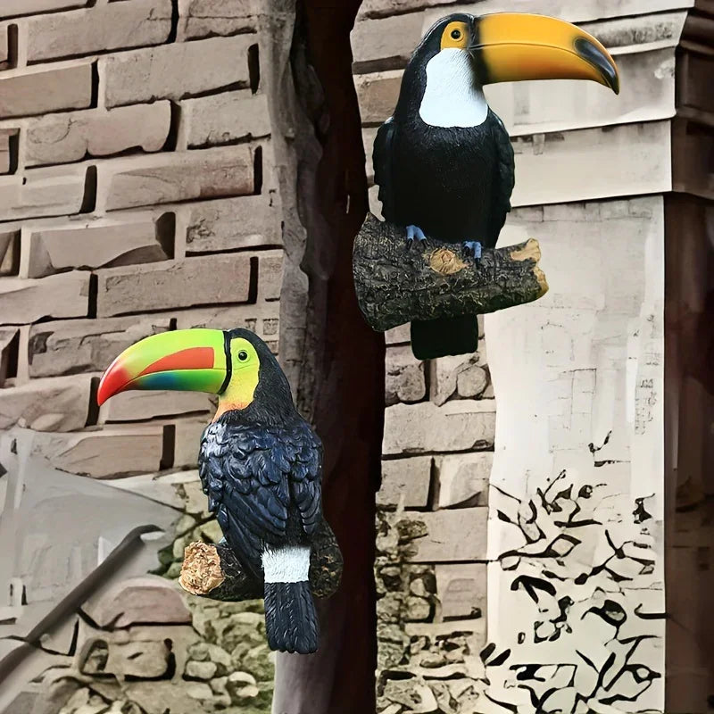 Two toucan statues on a stone wall background