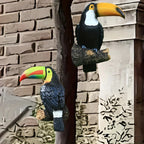 Two toucan statues on a stone wall background