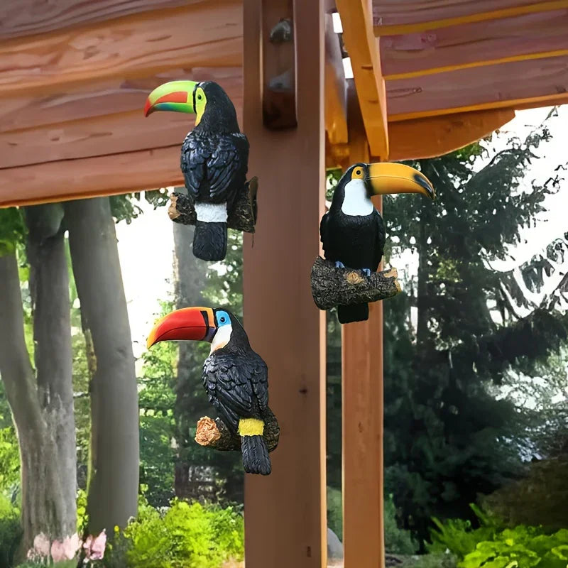 Three decorative toucan figures on a wooden structure with a natural background