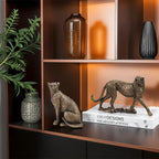 Decorative shelf with animal figurines, vases, and books on a wooden shelf.