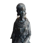 Bronze-colored african women sculpture figurine with textured surface wearing layered necklaces and large hoop earrings