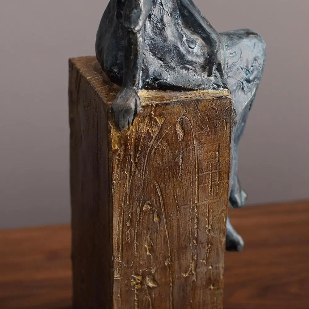 Dark gray textured metal sculpture of a seated dog on rustic wooden pedestal in african women sculpture decor style