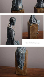 Dark gray textured resin african women sculpture of a seated figure with large hoop earrings for cultural decor