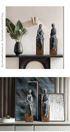 Two dark bronze african women sculpture figurines with draped fabric on wooden bases for cultural decor