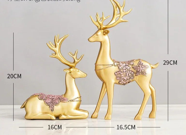 Golden deer figurine set featuring crystal floral accents with intricate pink lace-like floral embellishments on their backs