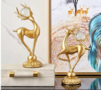 Golden deer figurine with antlers holding a clear crystal orb featuring crystal floral accents in a decorative set