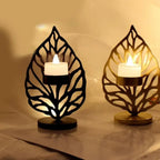 Black and gold leaf metal candle holder with intricate cut-out designs holding glowing led tea lights