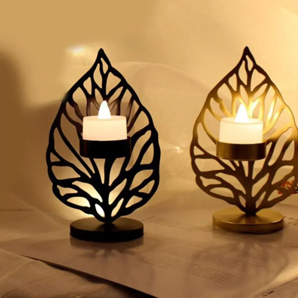 Black and gold leaf metal candle holder with intricate cut-out designs holding glowing led tea lights