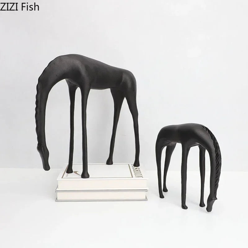 Modern minimalist black matte-finished abstract giraffe figurines with bowed necks complement minimalist black horse sculpture decor
