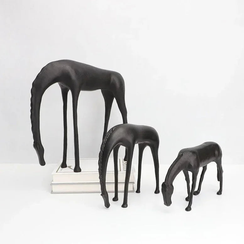Set of three sleek modern minimalist black horse sculpture figurines with elongated legs and stylized necks in matte finish