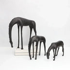 Set of three sleek modern minimalist black horse sculpture figurines with elongated legs and stylized necks in matte finish